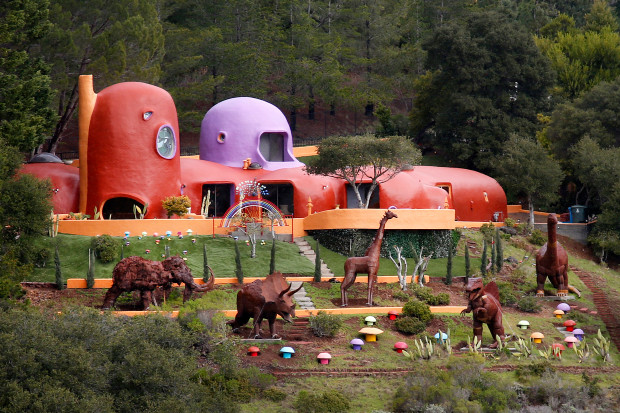 A menagerie of prehistoric animals now stands guard at the famous Flintstone House, Tuesday, March 13, 2017, in Hillsborough, Calif. Three dinosaurs, a giraffe and a mastadon were added by Florence Fang, the home's new owner. (Karl Mondon/Bay Area News Group)