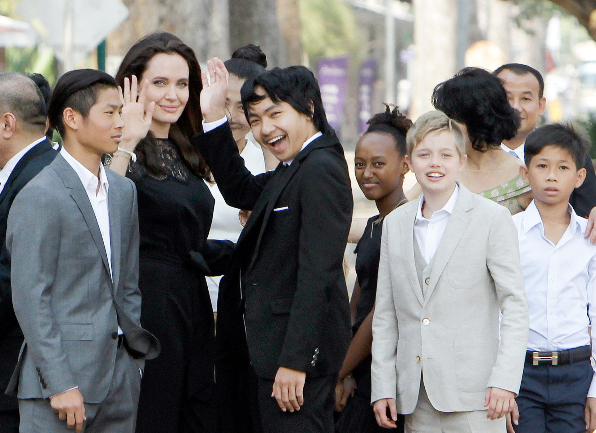 Hollywood actress Angelina Jolie, second from left, waves with her adopted children Pax, left, Maddox, center, Zahara, third from right, and Shiloh, second from right, while they wait to meet Cambodia's King Norodom Sihamoni in Siem Reap province, Cambodia, Saturday, Feb. 18, 2017. Jolie on Saturday launches her two-day film screening of "First They Killed My Father" in the Angkor complex in Siem Reap province. (AP Photo/Heng Sinith)